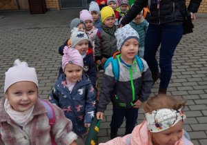 Dzieci sustawione parami, idą do autobusu