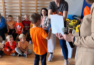 Chłopiec otrzymuje dyplom i nagrodę