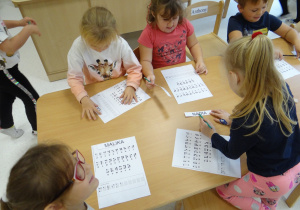 Ola, Zuzia, Malika, Nadia i Antoś zapisują swoje imię za pomocą alfabetu Breila.