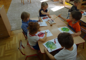 Dzieci malują obrazek farbami