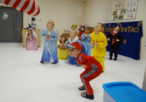 Dzieci w przebraniach tańczą wykonując odpowiednie ruchy.
