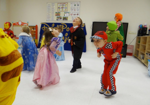 Dzieci w przebraniach tańczą do piosenki wykonując dziwne pozy.