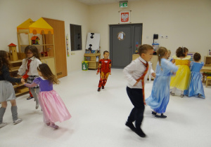 Dzieci w przebraniach tańczą.