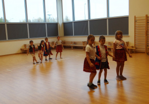 Żabki uczą się na sali gimnastycznej tańczyć trojaka.
