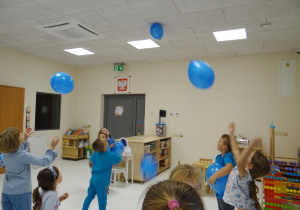 Dzieci obserwują balon, który naelektryzował się i "przykleił" do sufitu.