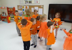 Żabki ubrane na pomarańczowo tańczą na powitanie.