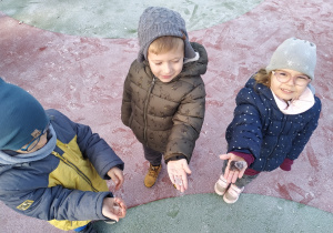 Igor, Szymon i Matylda pokazują swoje lodowe znaleziska.