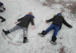 Laura i Antoś robią anioły na śniegu.