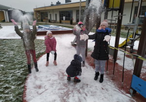 Dziewczynki rzucają śniegiem.