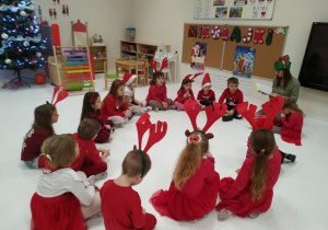 Nauczycielka czyta dzieciom opowiadanie o świętym Mikołaju.