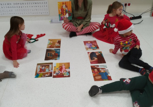 Nauczycielka pokazuje ilustracje dotyczące życia świętego Mikołaja.