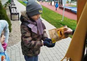 Pani wysypuje Antosiowi słonecznik na dłonie.