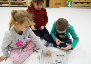 Ola, Zuzia i Lena przeszukują piasek w poszukiwaniu "kości" dinozaura.