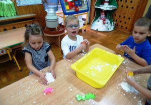 Dzieci bawią się sztucznym śniegiem