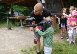 Szymonek strzela z pistoletu do paintballa.