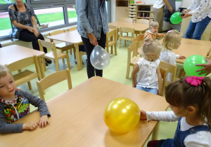 Dzieci siedzą przy stolikach