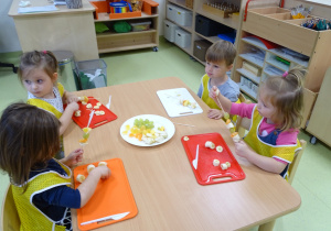 Dzieci nakłuwają owoce na patyki
