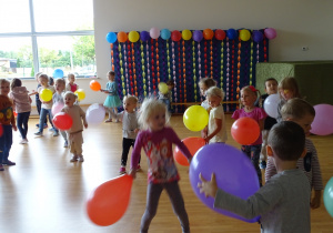 Dzieci tańczą trzymając kolorowe balony.