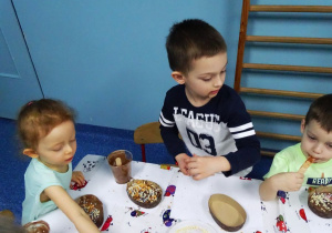 Dzieci ozdabiają czekoladowe jajeczka