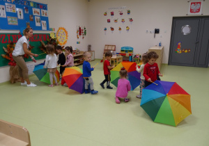 Dzieci grają na parasolach pałeczkami