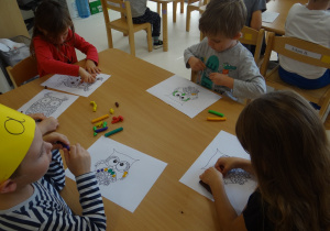 Dzieci wyklejają obrazek sowy plasteliną