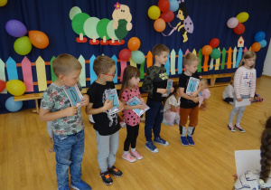Dzieci stoją z literkami w rękach tworząc napis dzień