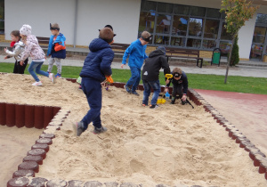 Dzieci szukają skarbu zakopanego w piaskownicy