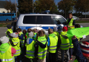 Policjantka prezentuje dzieciom radiowóz
