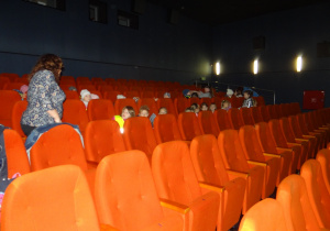 Przedszkolaki siedzą na fotelach w sali kinowej