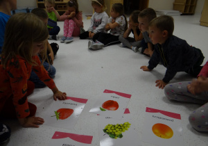 Dzieci oglądają obrazki owoców