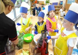 Dzieci w strojach kucharzy podczas robienia soku