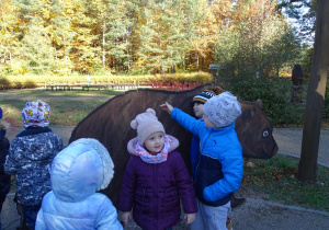 Dzieci dotykają eksponat niedźwiedzia