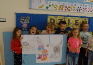 Dzieci prezentują plakat z psem