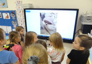 Dzieci oglądają zdjęcia pieska na tablecie