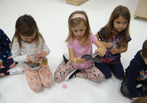 Dziewczynki oglądają kocie zabawki