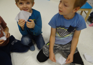 Chłopcy pokazują pieska złożonego z papieru