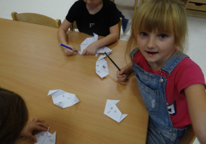 Dzieci rysują pyszczki zwierzątkom z papieru