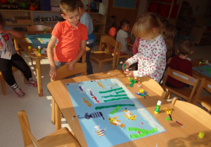 Dzieci wykonują prace plastyczną akwarium