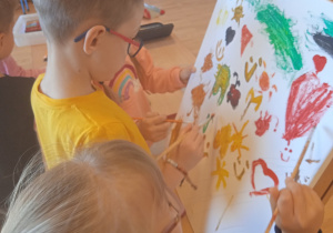 Dzieci malują obraz.