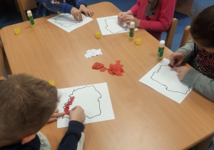 Dzieci wyklejają mapę Polski.