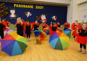 Dzieci tańczą za parasolem