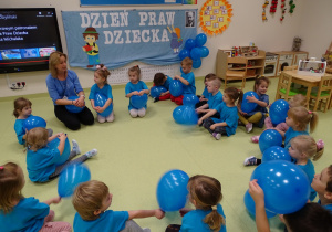 Dzieci siedzą w kole z balonami