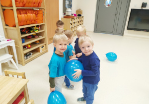 Franio i Seba bawią się niebieskim balonem - trzymają go swoimi brzuchami.