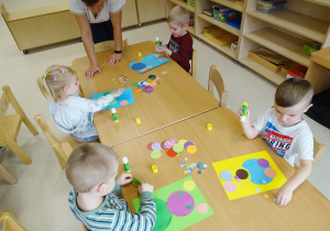 Dzieci wykonują pracę plastyczną z kół.