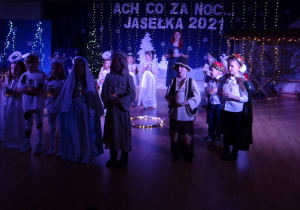 Dzieci stoją z lampionami podczas występu