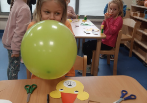 Oliwia nadmuchuje balon.