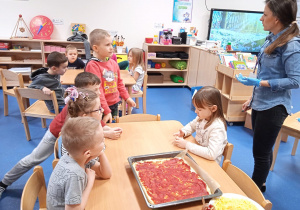 Dzieci wspólnie przygotowują pizze.