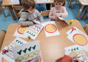 Dzieci wykonują pizzę na kartach papieru