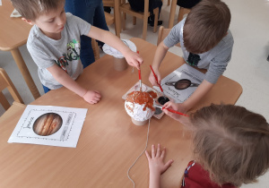 Chłopcy malują model Jowisza i Saturna