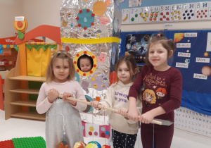 Dziewczynki prezentują pomalowany model Układu słonecznego